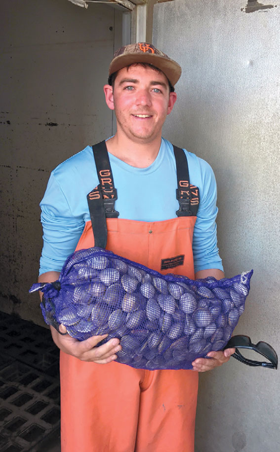 Billy Mayer holding a net of clams