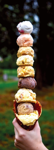 Multiple scoops of fresh churned ice cream in a waffle cone