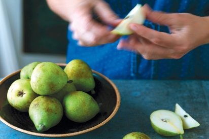 close up of hands cutting green apples