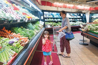 A girl and her mother shop in the fresh produce section of H Mart