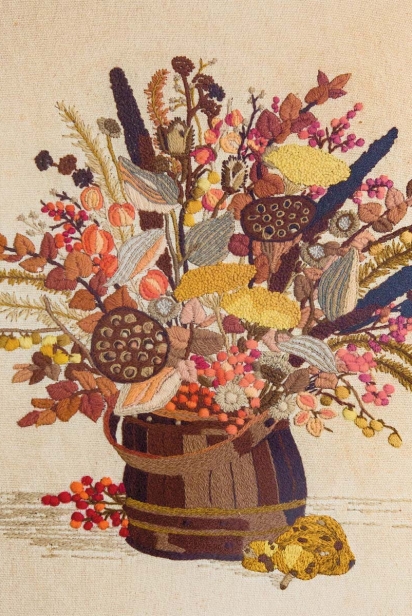 A vintage floral needlecraft, made by Danny Child’s great-grandmother, hangs in the couple’s home kitchen.