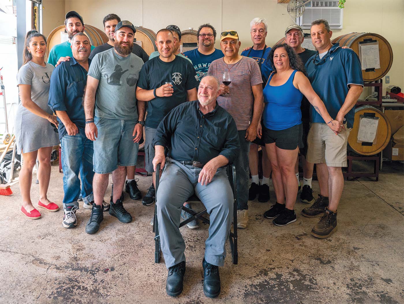 Sandy Moscaritolo (c. seated) leads a rotating group making wine in Elizabeth, where he grew up and has been making wine for 50 years.